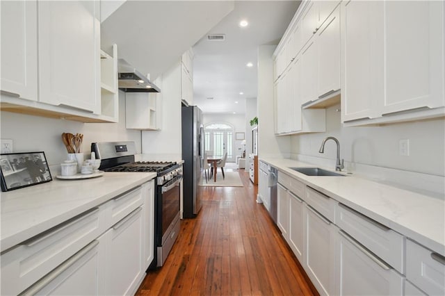20810 S Scott St, New Orleans, LA 70119 - kitchen featuring appliances with stainless steel finishes, exhaust hood, white cabinetry, dark wood-type flooring, and recessed lighting