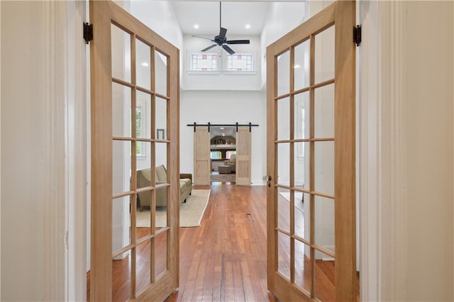 20810 S Scott St, New Orleans, LA 70119 - corridor with french doors, hardwood / wood-style flooring, a towering ceiling, and a barn door