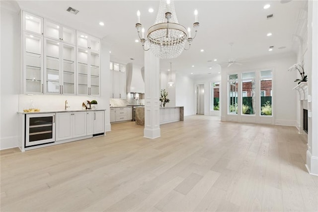 108 Dorrington Blvd, Metairie, LA 70005 - unfurnished living room featuring wine cooler, a chandelier, light wood-style floors, recessed lighting, and a ceiling fan