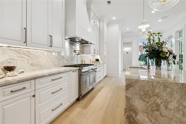 108 Dorrington Blvd, Metairie, LA 70005 - kitchen with premium range hood, double oven range, ornamental molding, white cabinetry, and light stone countertops