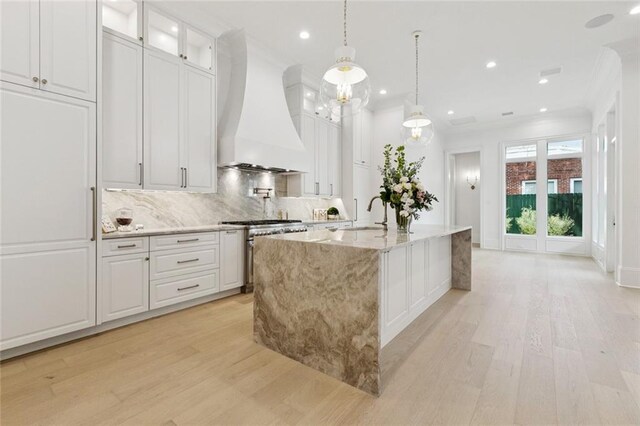 108 Dorrington Blvd, Metairie, LA 70005 - kitchen featuring custom exhaust hood, high end stainless steel range, light wood finished floors, a center island with sink, and recessed lighting