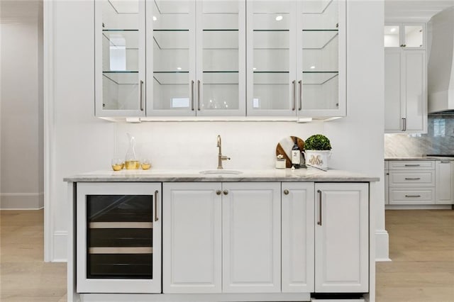 108 Dorrington Blvd, Metairie, LA 70005 - indoor wet bar featuring wine cooler, decorative backsplash, light wood-style floors, and wall chimney range hood