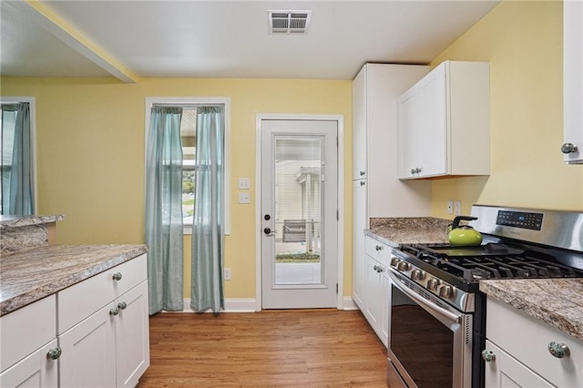 3713 Lausat St, Metairie, LA 70001 - kitchen with gas stove, light wood-style flooring, white cabinets, and light countertops