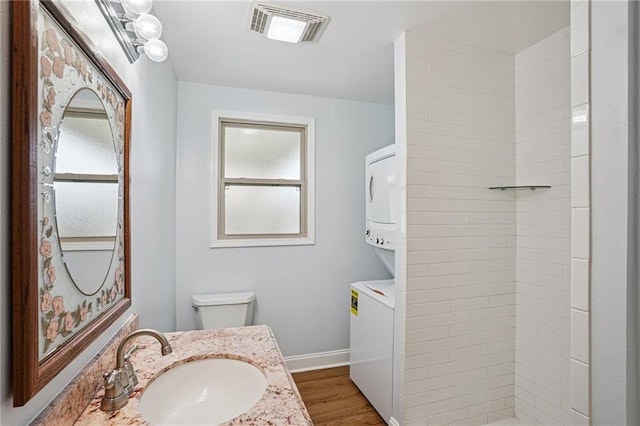 3713 Lausat St, Metairie, LA 70001 - full bath with stacked washer / dryer, vanity, tiled shower, and wood finished floors