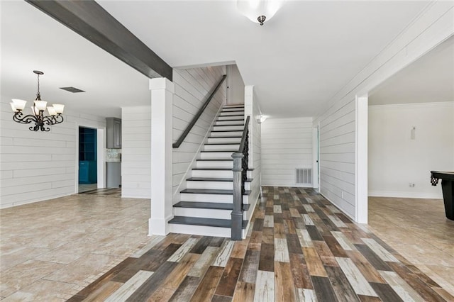 4625 Cleveland Pl, Metairie, LA 70003 - stairs with wood walls, a chandelier, and wood finished floors