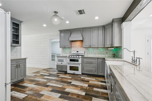 4625 Cleveland Pl, Metairie, LA 70003 - kitchen with gray cabinets, white appliances, custom range hood, dark wood-type flooring, and light stone countertops