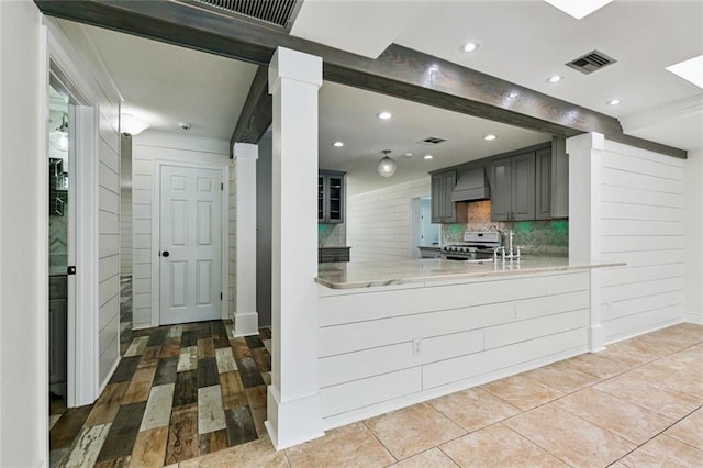 4625 Cleveland Pl, Metairie, LA 70003 - kitchen with stove, custom range hood, tasteful backsplash, gray cabinets, and a peninsula