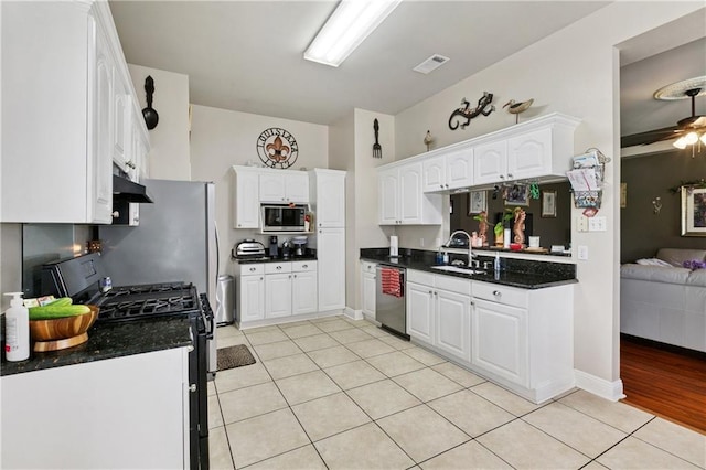 4501 13th St, Marrero, LA 70072 - kitchen with appliances with stainless steel finishes, dark countertops, light tile patterned floors, and white cabinets