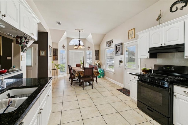 4501 13th St, Marrero, LA 70072 - kitchen with black gas stove, under cabinet range hood, a chandelier, white cabinetry, and light tile patterned flooring