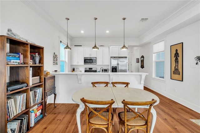 436 S Cortez St, New Orleans, LA 70119 - dining area with light wood-style floors, crown molding, and recessed lighting