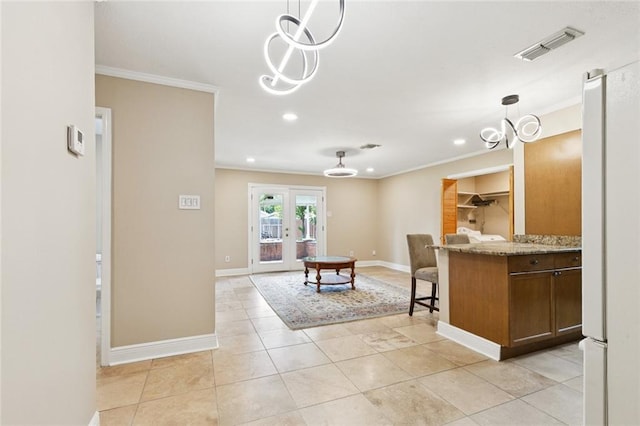 4513 Dreyfous Ave, Metairie, LA 70006 - kitchen featuring ornamental molding, pendant lighting, recessed lighting, light stone countertops, and freestanding refrigerator