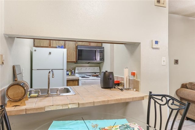 2330 Edenborn Ave Unit 116, Metairie, LA 70001 - kitchen featuring white appliances, tile countertops, and brown cabinetry
