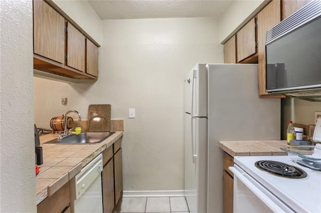 2330 Edenborn Ave Unit 116, Metairie, LA 70001 - kitchen with white appliances, tile countertops, light tile patterned floors, and a textured ceiling
