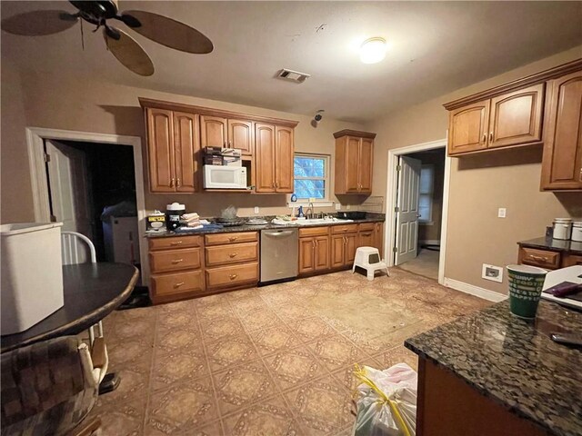 2986 Palm Dr, Slidell, LA 70458 - kitchen featuring stainless steel dishwasher, white microwave, a ceiling fan, and brown cabinetry