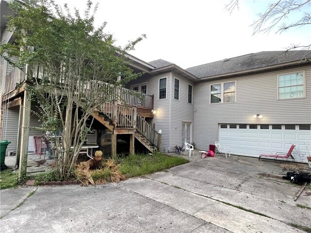2986 Palm Dr, Slidell, LA 70458 - rear view of property with an attached garage, stairway, concrete driveway, a wooden deck, and a shingled roof