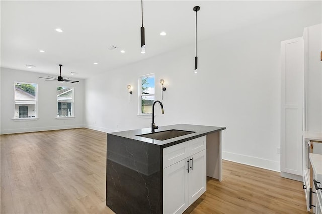 1871 N Roman St, New Orleans, LA 70116 - kitchen with healthy amount of natural light, light wood finished floors, recessed lighting, ceiling fan, and a center island with sink