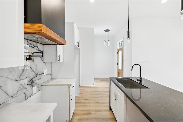 1871 N Roman St, New Orleans, LA 70116 - kitchen with premium range hood, white cabinets, recessed lighting, light wood-style flooring, and dark stone countertops