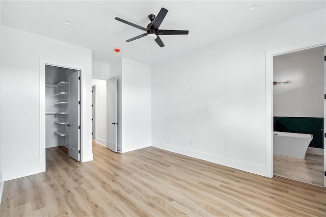 1871 N Roman St, New Orleans, LA 70116 - unfurnished bedroom featuring a spacious closet, light wood-style flooring, a closet, ceiling fan, and ensuite bath
