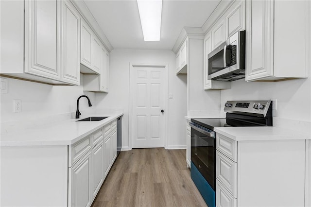 1828 San Francisco Rd, La Place, LA 70068 - kitchen with stainless steel appliances, light wood-style floors, white cabinetry, and light countertops