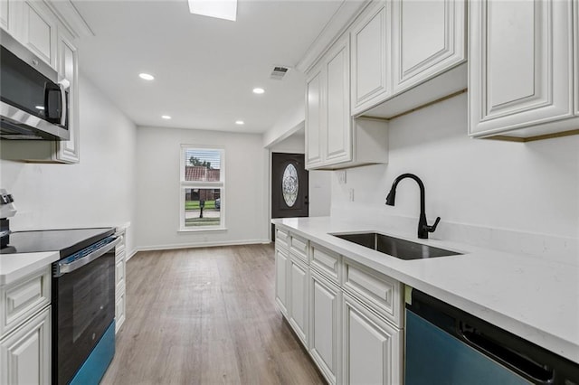 1828 San Francisco Rd, La Place, LA 70068 - kitchen featuring appliances with stainless steel finishes, light countertops, light wood-type flooring, white cabinets, and recessed lighting