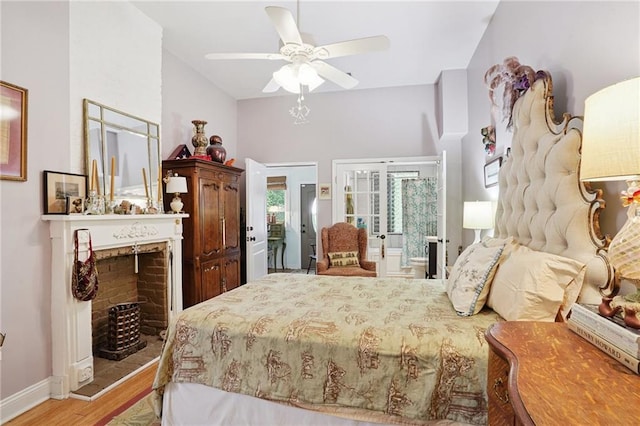 626 Independence St, New Orleans, LA 70117 - bedroom with light wood-style flooring, ceiling fan, vaulted ceiling, french doors, and a fireplace