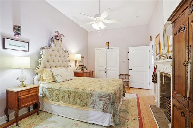 626 Independence St, New Orleans, LA 70117 - bedroom featuring light wood-style floors, a brick fireplace, a closet, and ceiling fan