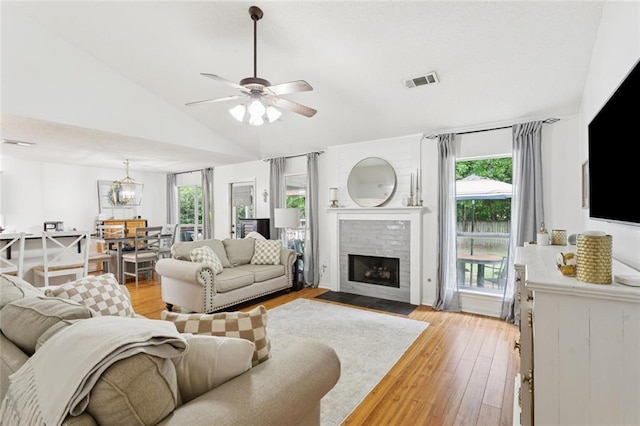 240 Emerald Crk W, Abita Springs, LA 70420 - living area with light wood-style flooring, lofted ceiling, a fireplace, and a ceiling fan