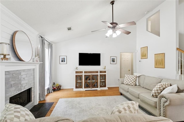 240 Emerald Crk W, Abita Springs, LA 70420 - living room featuring a ceiling fan, a brick fireplace, wood finished floors, lofted ceiling, and stairs