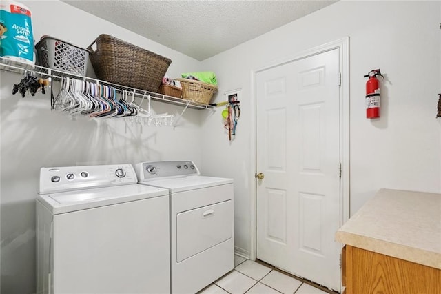 240 Emerald Crk W, Abita Springs, LA 70420 - laundry area featuring washer and dryer, light tile patterned floors, and a textured ceiling