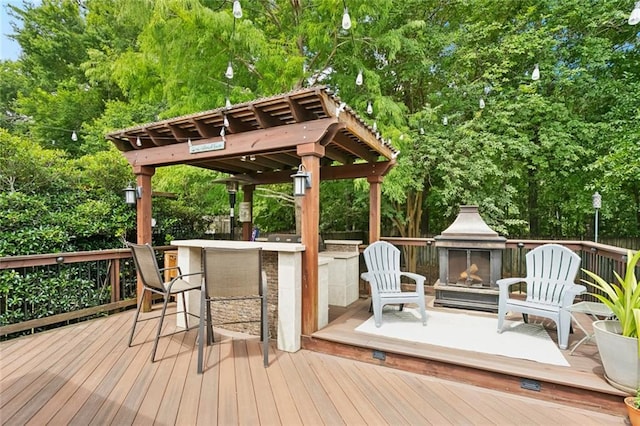 240 Emerald Crk W, Abita Springs, LA 70420 - wooden deck with an outdoor fireplace and view of wooded area