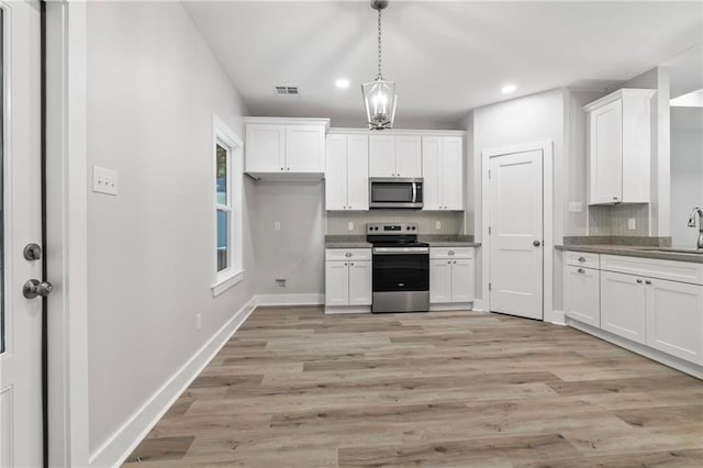 74446 Delta Ave, Covington, LA 70435 - kitchen featuring appliances with stainless steel finishes, tasteful backsplash, white cabinets, recessed lighting, and light wood finished floors