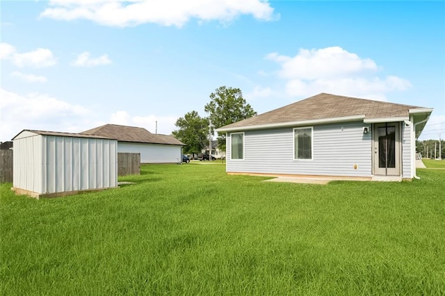 42310 Andrea Ln, Ponchatoula, LA 70454 - rear view of property featuring a yard, a storage unit, and a shingled roof