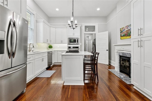4532-34 Chestnut St, New Orleans, LA 70115 - kitchen featuring stainless steel appliances, a fireplace, a kitchen breakfast bar, light countertops, and recessed lighting