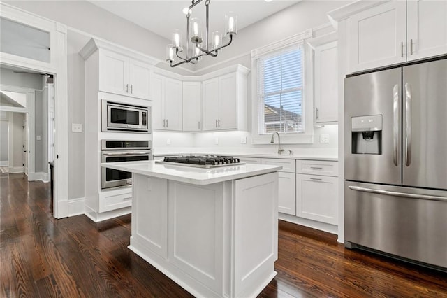 4532-34 Chestnut St, New Orleans, LA 70115 - kitchen featuring appliances with stainless steel finishes, light countertops, a chandelier, white cabinetry, and dark wood-style flooring