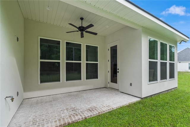 1169 Fox Sparrow Loop, Madisonville, LA 70447 - rear view of property featuring a ceiling fan, stucco siding, a patio area, and a lawn