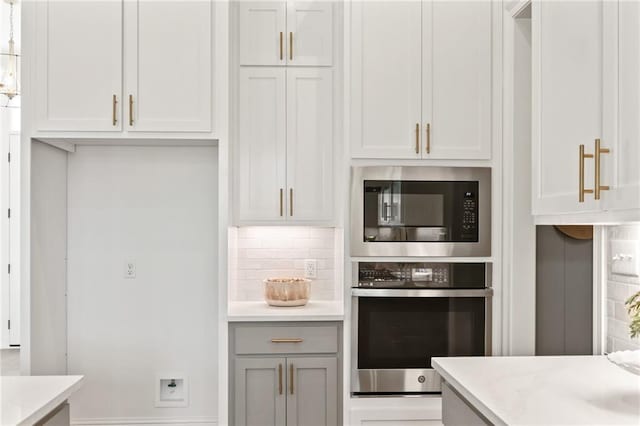 4141 Endor Loop, Mandeville, LA 70448 - kitchen with appliances with stainless steel finishes, backsplash, light stone countertops, and gray cabinets