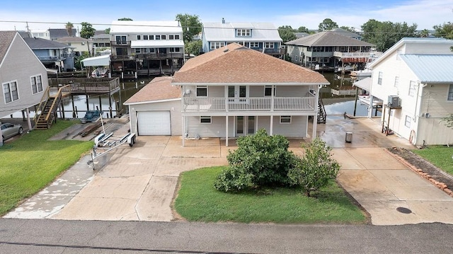 168 Terry Dr, Slidell, LA 70458 - view of front of property featuring concrete driveway, a residential view, a garage, a front lawn, and a water view