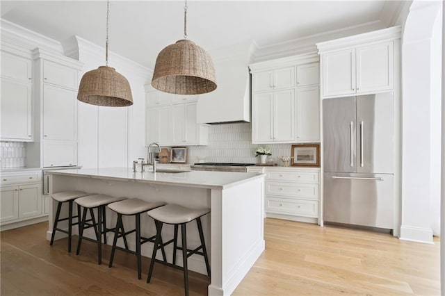 303 W William David Pkwy, Metairie, LA 70005 - kitchen with stainless steel built in fridge, crown molding, premium range hood, backsplash, and light wood finished floors