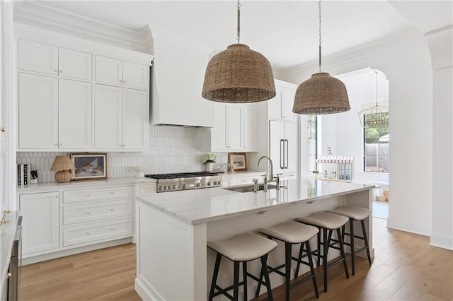 303 W William David Pkwy, Metairie, LA 70005 - kitchen with crown molding, range, custom exhaust hood, backsplash, and light wood-style flooring