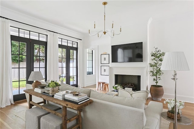 303 W William David Pkwy, Metairie, LA 70005 - living area featuring a chandelier, light wood-style floors, a fireplace, and french doors