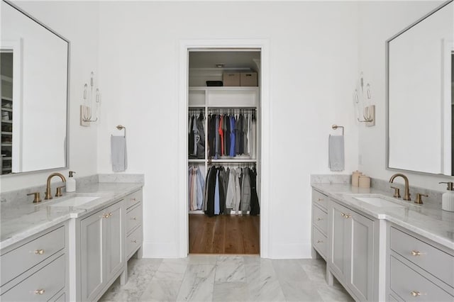 303 W William David Pkwy, Metairie, LA 70005 - full bathroom with two vanities, marble finish flooring, and a walk in closet