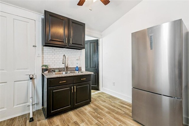 112830 N Roman St, New Orleans, LA 70116 - kitchen featuring freestanding refrigerator, backsplash, a ceiling fan, dark brown cabinets, and light wood finished floors