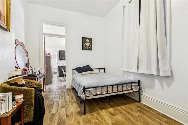 112830 N Roman St, New Orleans, LA 70116 - bedroom with light wood-style floors and fridge
