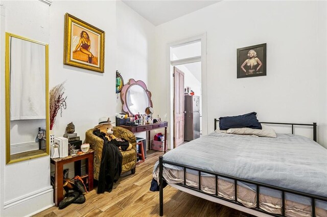 112830 N Roman St, New Orleans, LA 70116 - bedroom with wood finished floors and freestanding refrigerator