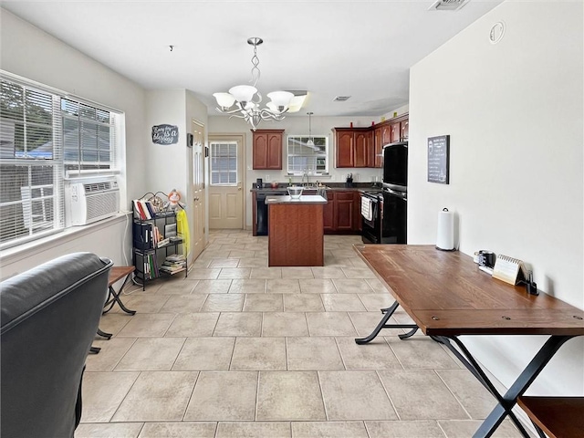 2411 Jay St, Slidell, LA 70460 - kitchen with a chandelier, a kitchen island, black appliances, decorative light fixtures, and open floor plan