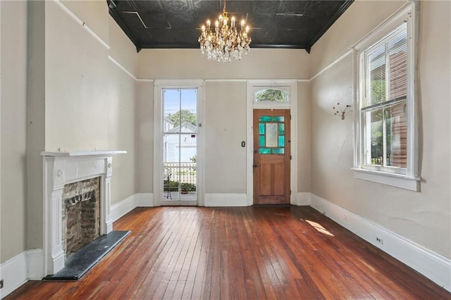 820-22 N Salcedo St, New Orleans, LA 70119 - foyer with hardwood / wood-style floors, a chandelier, a fireplace, and an ornate ceiling