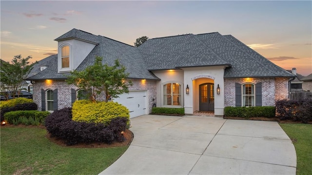 1104 Cypress Crossing Dr, Madisonville, LA 70447 - french country home with driveway, brick siding, a garage, and a front yard