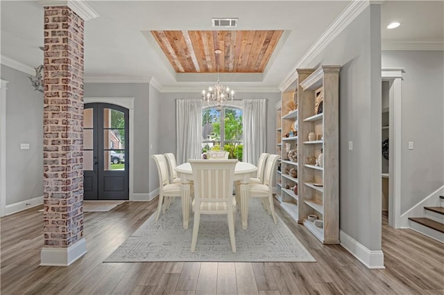 1104 Cypress Crossing Dr, Madisonville, LA 70447 - dining area with a chandelier, wood finished floors, crown molding, stairs, and decorative columns
