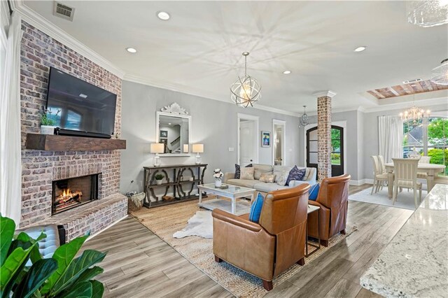 1104 Cypress Crossing Dr, Madisonville, LA 70447 - living area with wood finished floors, recessed lighting, a brick fireplace, a chandelier, and ornamental molding
