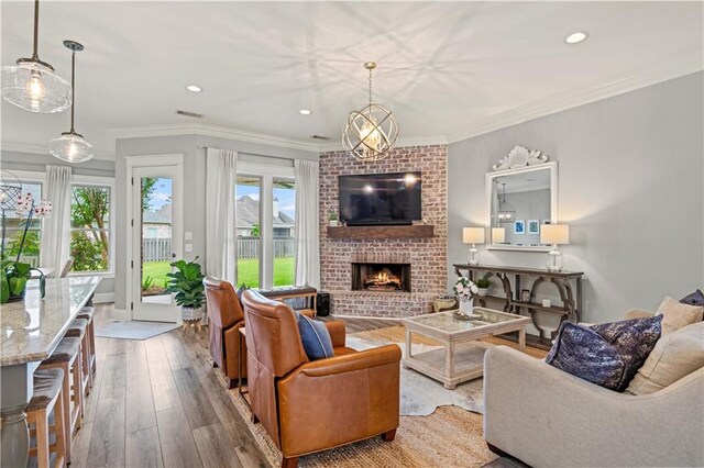 1104 Cypress Crossing Dr, Madisonville, LA 70447 - living room with hardwood / wood-style flooring, a fireplace, ornamental molding, and recessed lighting